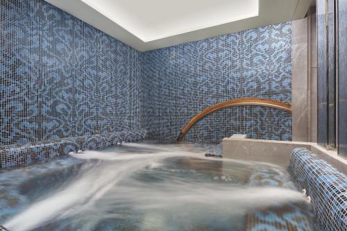 义乌义乌万豪行政公寓的浴室设有蓝色瓷砖和热水浴缸
