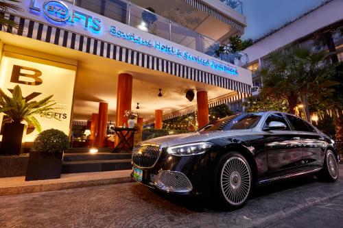 芭东海滩BYD Lofts - Boutique Hotel & Serviced Apartments - Patong Beach, Phuket的停在大楼前的一辆黑色汽车