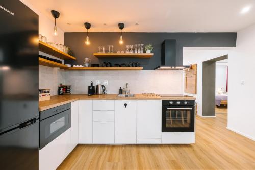 普利比利那Serenity的厨房配有白色橱柜和黑色家电