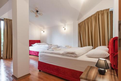 斯科普里Lux House with own parking in Skopje的红色和白色的客房内的两张床