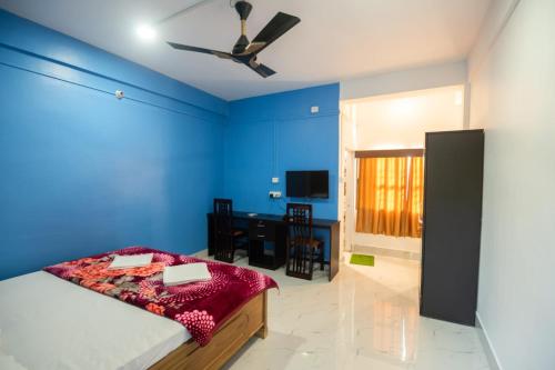 卡齐兰加Jungle Eco Mansion的蓝色卧室配有一张床和一张书桌