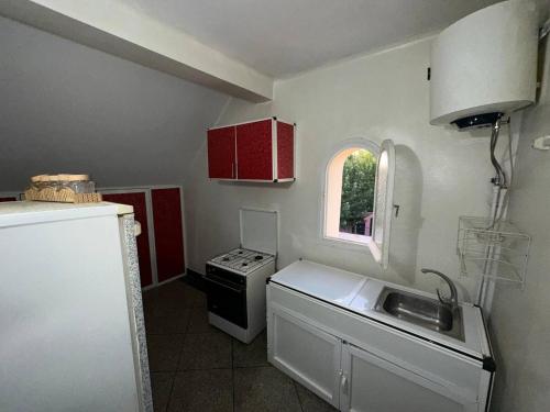 伊夫兰La pivoine jaune的厨房配有水槽、炉灶和窗户。