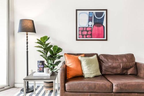 悉尼Chippendale 1 Bedroom Apartment • Mins to Central的客厅配有棕色沙发和桌子