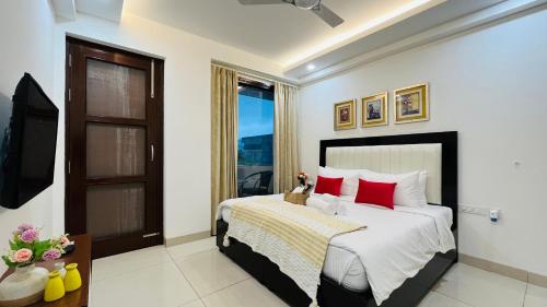 古尔冈BluO 3BHK Golf Course Road - Balcony, Lift, Terrace的一间卧室配有一张带红色枕头的大床