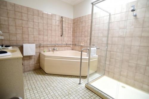 贝纳拉Benalla Apartments的设有带浴缸和淋浴的浴室。