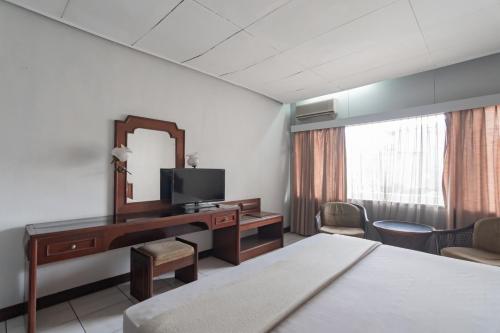 万隆Istana Hotel Bandung Mitra RedDoorz的酒店客房配有书桌和镜子