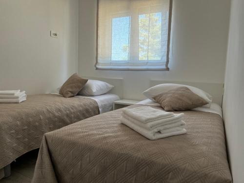 斯拉汀Apartment Rovci 1的一间卧室配有两张带毛巾的床