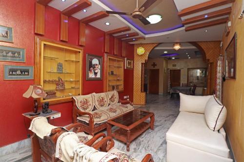 布巴内什瓦尔OYO Flagship 33400 Omm Sai Plaza的客厅设有红色的墙壁和沙发。