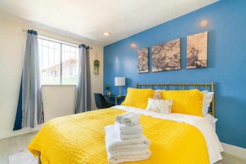 奥克兰Modern Cottage near many conveniences的蓝色卧室配有黄色的床和毛巾
