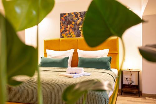 茨维考FeelgooD Apartments LOFT Zwickau CityCenter mit TG-Stellplatz, Netflix, Waipu-TV und Klima的一张带橙色床头板和绿色枕头的床