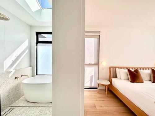 邓斯伯勒Amila - central location with designed spaces的一间带浴缸的卧室和一张带窗户的床