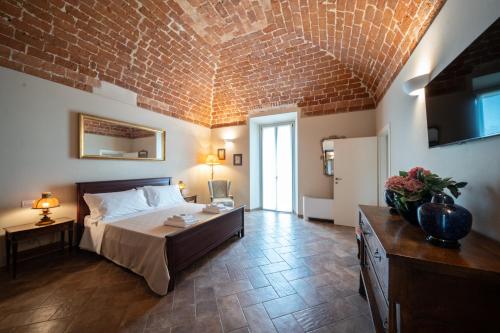 TerruggiaCascina Baronina的一间卧室设有一张床和砖墙