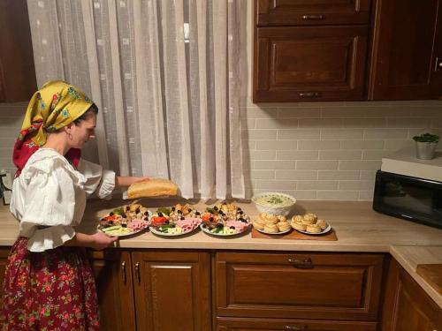 耶乌德Casa pintioi的站在厨房里拿着食物盘的女人