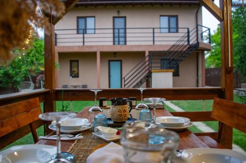 穆里吉奥尔Casa lui Matei Murighiol的一张带食物盘的木桌和一座房子