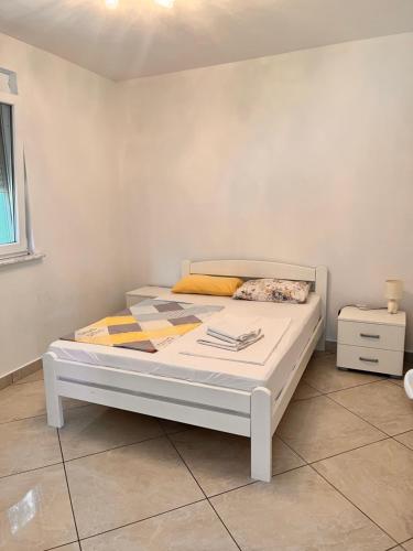 尤塔哈Apartments Apartmani Bojana的白色墙壁的房间里一张白色的床