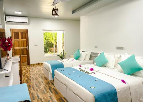 福拉杜岛Island Luxury Dive Hotel - Fulhadhoo的蓝色和白色的客房内的两张床