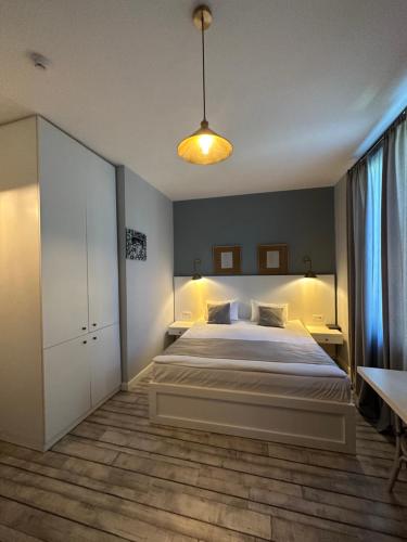 库塔伊西Hotel Ticiani 13的卧室配有一张白色的大床和一张桌子