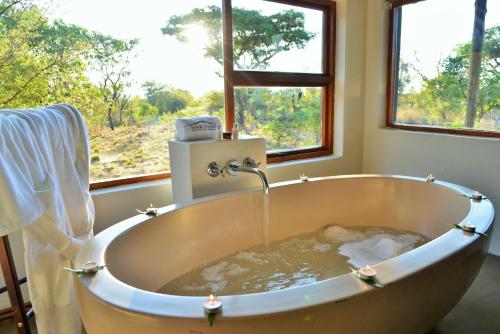 马布拉Safari Plains的窗户前装满水的浴缸