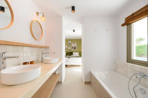 塞斯派瑟斯Villa Maria - Luxury Getaway的浴室设有2个水槽、浴缸和镜子