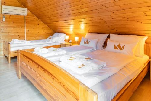 博德森特克Bella Mura Nature Chalet I27的小木屋内的两张床,配有白色床单
