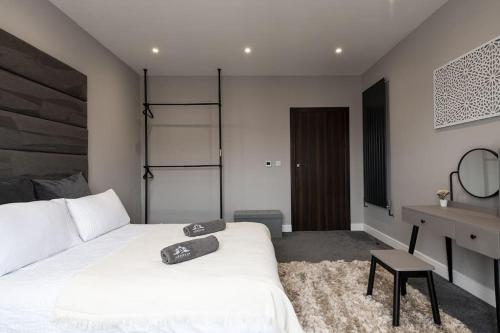 吉林汉姆Luxury Apartments in Gillingham的一间卧室配有两张白色的床和一张书桌