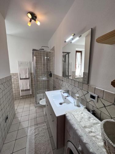 普雷圣迪迪埃Bilocale Centro Pré-Saint-Didier的浴室配有白色水槽和淋浴。