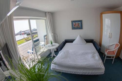 黑尔戈兰岛鸿恩霍尔特酒店的小房间设有一张床和一个阳台
