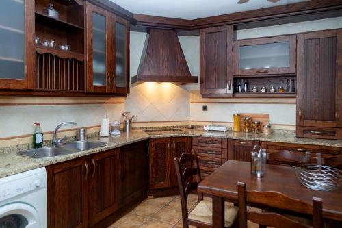 PolánLos olivares de Rober的厨房配有木制橱柜、桌子和水槽。