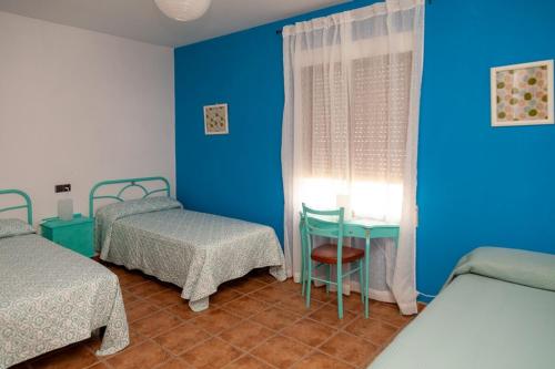 PolánLos olivares de Rober的客房设有两张床、一张桌子和一扇窗户。