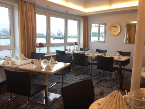 汉堡Hotel AM ELBUFER的用餐室设有桌椅和窗户。