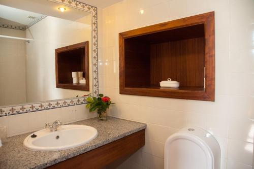 曼泰加什卡萨达斯奥布拉斯酒店的一间带水槽、镜子和卫生间的浴室