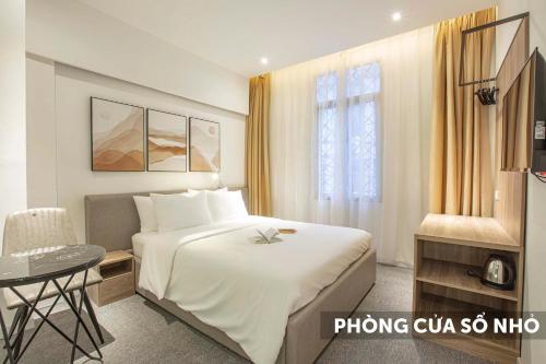 河内Keypad - Saki Hotel - 28 Dịch Vọng Hậu, Cầu Giấy的酒店客房设有一张大床和一张桌子。