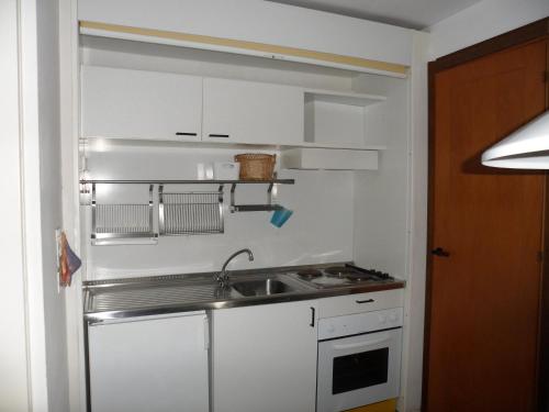 蓬塔阿拉Appartamento 109 - Multiproprietà I Boboli BC的小厨房配有白色橱柜和水槽