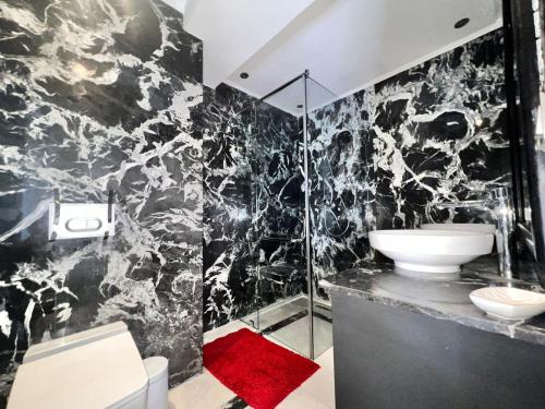 马拉喀什Majorelle Splendide Appartement的黑白浴室设有水槽和淋浴