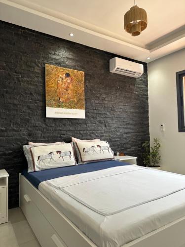 马拉喀什Majorelle Splendide Appartement的一间卧室设有一张床和砖墙