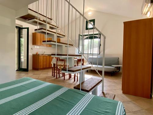 马蒂纳塔Villetta San Matteo的一间带一张床的客房和一间带螺旋楼梯的厨房