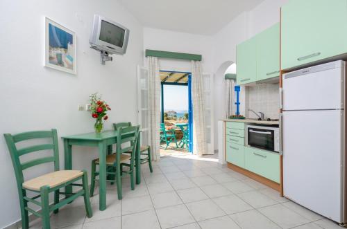 米科利维亚Victoria Studios & Apartments的厨房配有桌椅和冰箱。