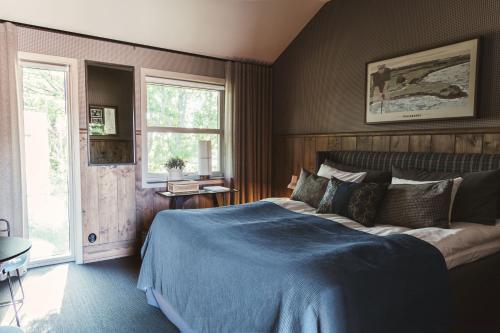 菲斯克拜克希尔Tweed Hotell Skaftö的一间卧室配有一张带蓝色毯子的大床