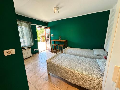 新戈里察Studio Apartma Olive, Nova Gorica, Slovenia的一间卧室设有两张床和绿色的墙壁