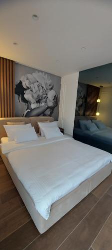 蒂瓦特La casa di Sonja的卧室配有一张白色大床,墙上挂有绘画作品
