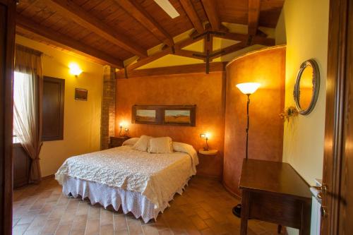 MontelopioBio Agriturismo Pratini的一间卧室配有一张床、一张桌子和一盏灯