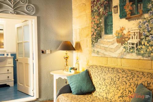 ŻebbuġRest, restore, explore. An exclusive stay in Malta的一间配有沙发的房间和墙上的绘画