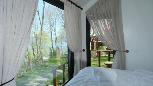 卡特佩MANZARA SUİTES ORMAN KÖY的一间卧室设有一张床和一个大窗户