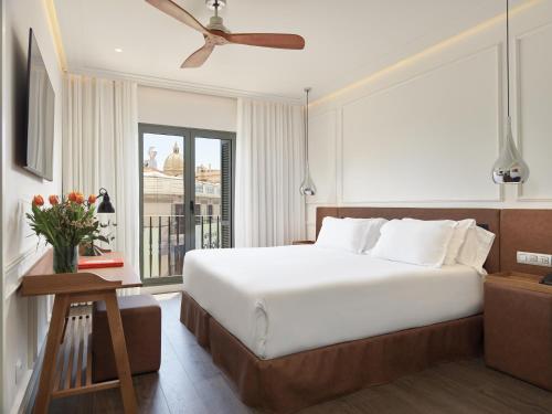 巴塞罗那H10大学酒店的一间卧室设有一张大床和一个窗户。