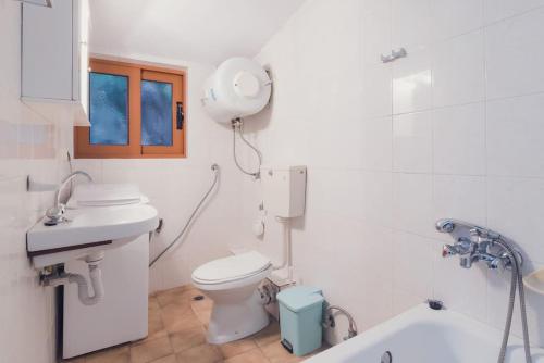 萨摩斯Beautiful Cottage over-viewing Samos bay.的一间带卫生间、水槽和镜子的浴室