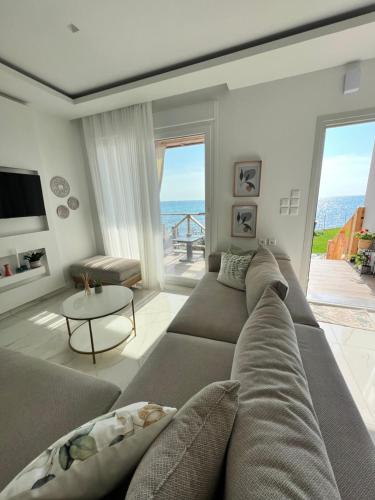 VergiaBeachfront Villa Athina的带沙发的客厅,享有海景