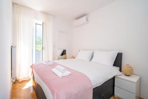 杜布罗夫尼克Villa MarLea的白色卧室配有一张带粉色毯子的大床