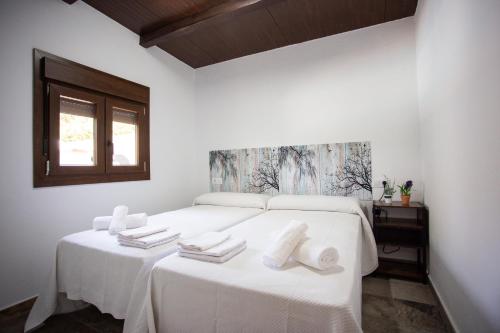 麦地那西多尼亚Casa Caramelo的一间卧室配有两张白色床和毛巾