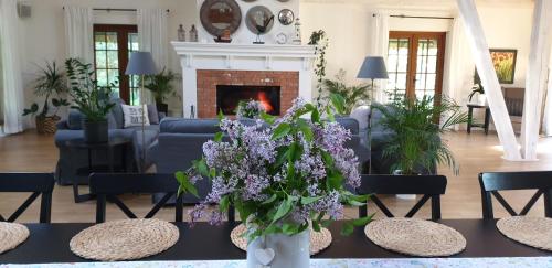 SuchowolaMajątek Morgi的客厅设有壁炉和带紫色花卉的桌子