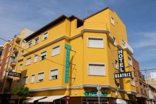 巴里亚纳比阿特丽斯酒店 的黄色建筑,标有酒店标志